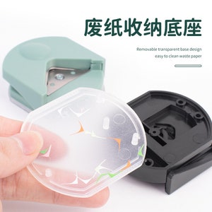 K&ouml;nnte beinhalten: Ein gr&uuml;ner und schwarzer Papier-Schneideger&auml;t mit einem abnehmbaren transparenten Sockel. Der Sockel ist so konzipiert, dass er das Reinigen von Abfallpapier erleichtert. Der Text auf dem Bild lautet "Removable transparent base design easy to clean waste paper".