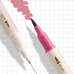 May include: Close-up of two dual-tip markers, one with a fine tip and the other with a brush tip. The brush tip marker is magenta, and the fine tip marker is white. A swatch of pink ink is visible, along with a pink line drawn by the fine tip marker.
