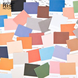 May include: A collection of colorful square paper swatches with the word "PANTONE" printed on them. The swatches are arranged in a random pattern and are a variety of colors, including red, orange, yellow, green, blue, purple, and brown.