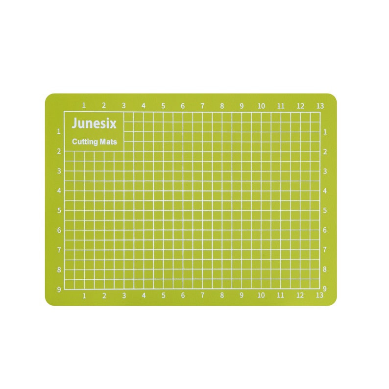 May include: A green self-healing cutting mat with a grid pattern and numbered lines. The mat is labeled "Junesix Cutting Mats".