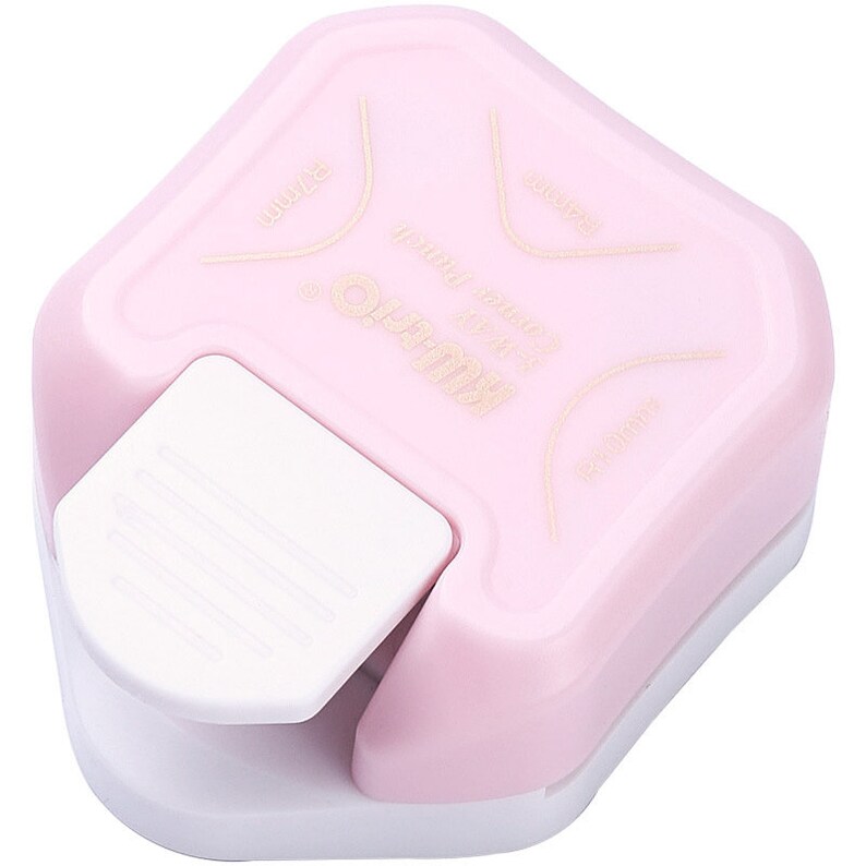 May include: A pink plastic paper punch with a white lever. The punch is designed to create a scalloped edge on paper. The text "KAWECO" is printed on the punch.