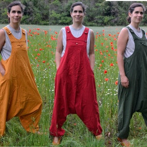 May include: Three women wearing different colored overalls. The overalls are a loose-fitting style with a wide leg. The women are standing in a field of red poppies.