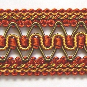 May include: Red, gold, and brown woven trim with a decorative pattern. The trim has a scalloped edge and a repeating design of circles and triangles.