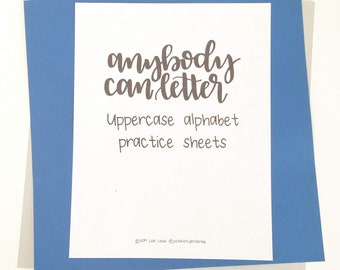 May include: A white sheet of paper with the words "anybody can letter" in brown script, and the text "Uppercase alphabet practice sheets" in a simple font. The paper is layered on blue and gray paper.