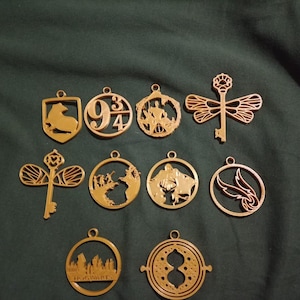 Puede incluir: Un conjunto de 11 adornos de metal de color dorado con diseños de Harry Potter. Los adornos incluyen un escudo de Hogwarts, una llave con alas, un dragón y el número 9 3/4.
