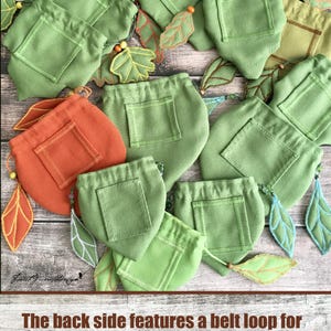 May include: A collection of green and orange pouches with a pocket on the front. The pouches are leaf-shaped and adorned with embroidered leaf accents. The back features a belt loop for a belt's width of up to 1.75 inches.
