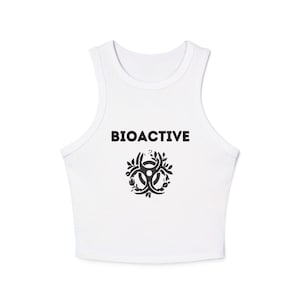 Może przedstawiać: Biały top z napisem "BIOACTIVE" w kolorze czarnym nad stylizowanym symbolem zagrożenia biologicznego z elementami kwiatowymi. Bezrękawnik wykonany jest z miękkiego, wygodnego materiału.