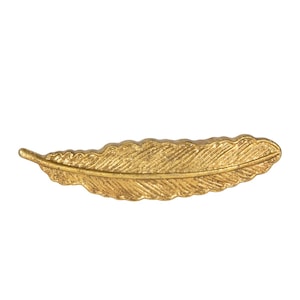 May include: A gold-coloured metal feather ornament. The feather is detailed with a textured surface.