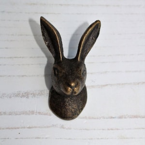 May include: A bronze rabbit head wall hook. The rabbit has a realistic design with a detailed face and ears.