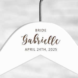 May include: White wooden hanger with the text "BRIDE Gabrielle APRIL 24TH, 2025" printed in brown.
