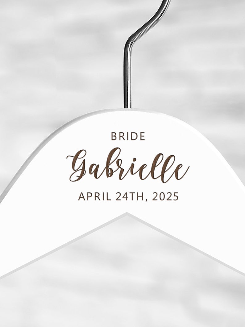 May include: White wooden hanger with the text "BRIDE Gabrielle APRIL 24TH, 2025" printed in brown.