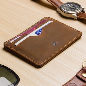 mens tan leather card holder wallet lifestyle shot, filled with cards