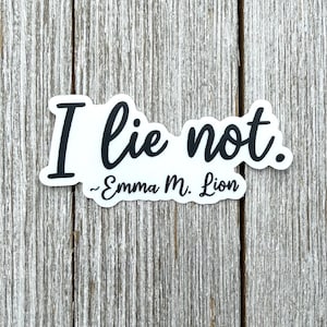 May include: A white die-cut sticker with a black border featuring the text I lie not. in a bold script font, followed by the name ~Emma M. Lion in a smaller script font below the main phrase, creating a clear and readable graphic design.