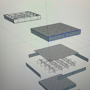 May include: A 3D model of a square metal grid with a 265 mm measurement. The grid is made up of four separate pieces, each with a number "1" or "2" printed on it. The grid is designed to be assembled into a larger structure.
