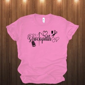 May include: Pink t-shirt with a black graphic that says "Sewcopath" with a needle, thread, thimble, scissors, and hearts.