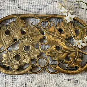 Può includere: Una tazza di ceramica bianca con manico nero e la scritta "But First, Coffee" in nero, con un carattere a mano. La tazza è su una superficie bianca.