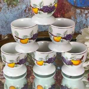 Seis hueveras francesas vintage con bonitos detalles de frutas con bordes dorados, Dulces hueveras de porcelana de los años 70 con decoración de peras y uvas, De Movitex