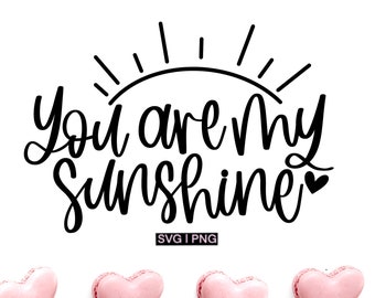 May include: A white background with the phrase "You are My Sunshine" in black script, with a sun graphic above. Below are four pink heart-shaped macarons. The image also includes the text "SVG | PNG".