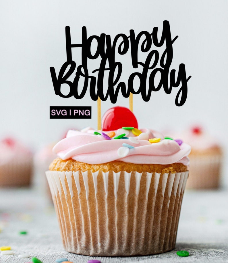 Puede incluir: Un cupcake rosa con chispas de colores y una cereza en la parte superior. Un adorno negro de "Feliz cumplea&ntilde;os" est&aacute; insertado en el cupcake.
