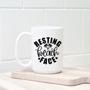 Może przedstawiać: Biały kubek ceramiczny z czarnym nadrukiem, na kt&oacute;rym widnieje napis "Resting Beach Face" z palmami w środku tekstu.
