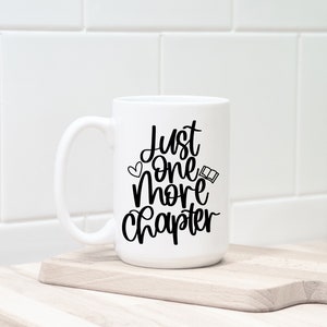 May include: White ceramic mug with a black design that says "Just one more chapter" with a small heart and open book graphic.