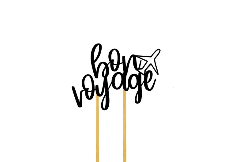 May include: Black and white cake topper with the text "bon voyage" and a small airplane graphic. The topper is on two gold sticks.