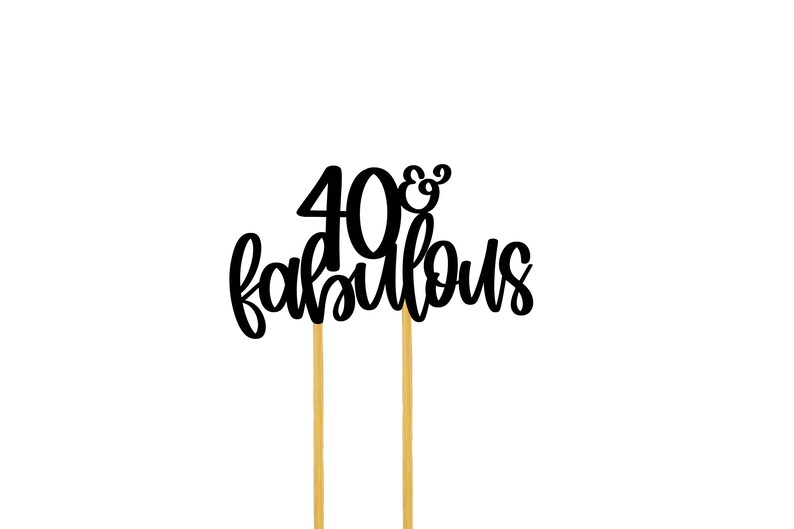 May include: Black cake topper with the text "40 & fabulous" on two gold sticks.