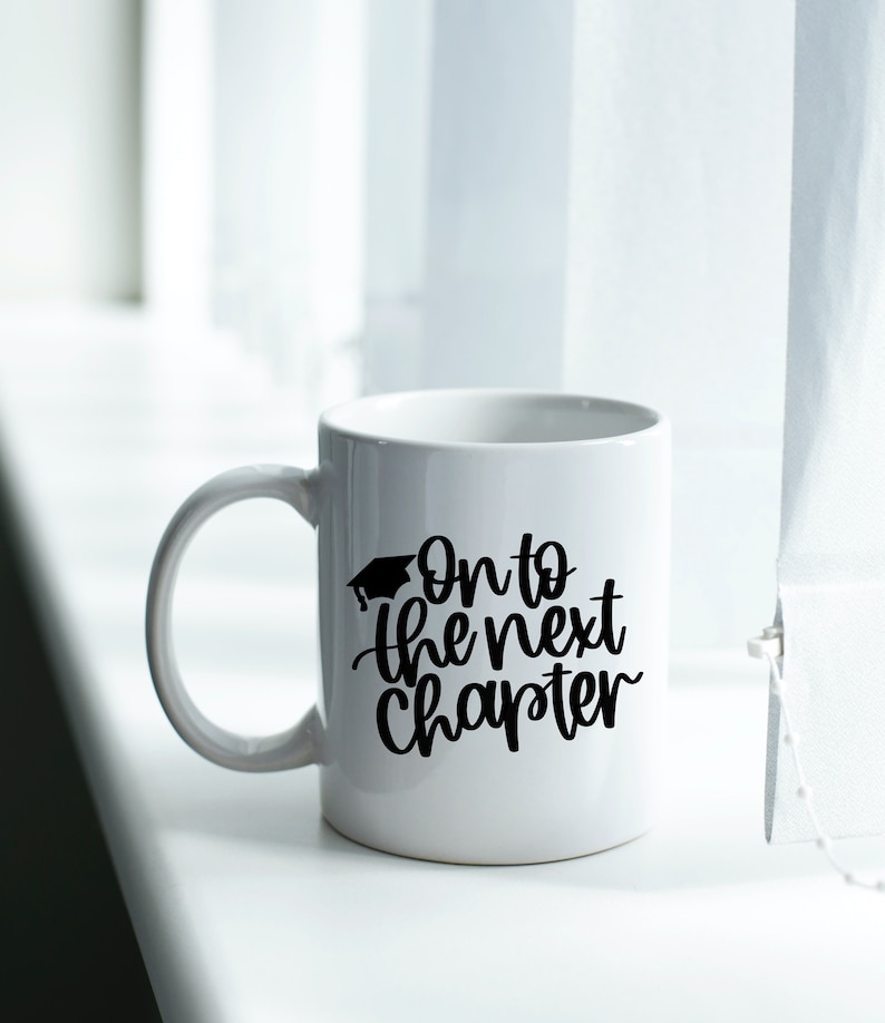 May include: White ceramic mug with a black graduation cap and the text "On to the next chapter" in black script.