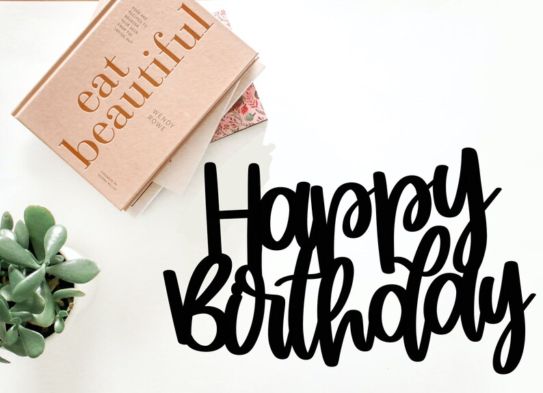 Puede incluir: Letras recortadas en negro que deletrean "Happy Birthday" sobre un fondo blanco.