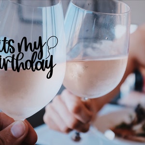 K&ouml;nnte beinhalten: Zwei Weingl&auml;ser gef&uuml;llt mit Ros&eacute;wein. Ein Glas hat einen schwarzen Vinyl-Aufkleber mit der Aufschrift "es ist mein Geburtstag" und einem kleinen Ballon-Motiv.