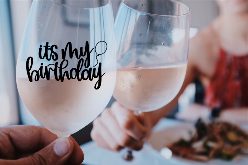 K&ouml;nnte beinhalten: Zwei Weingl&auml;ser gef&uuml;llt mit Ros&eacute;wein. Ein Glas hat einen schwarzen Vinyl-Aufkleber mit der Aufschrift "es ist mein Geburtstag" und einem kleinen Ballon-Motiv.