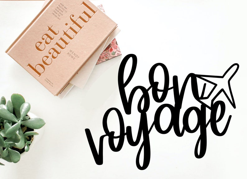 May include: Black and white cursive text that reads "bon voyage" with a small airplane icon next to the word "voyage".