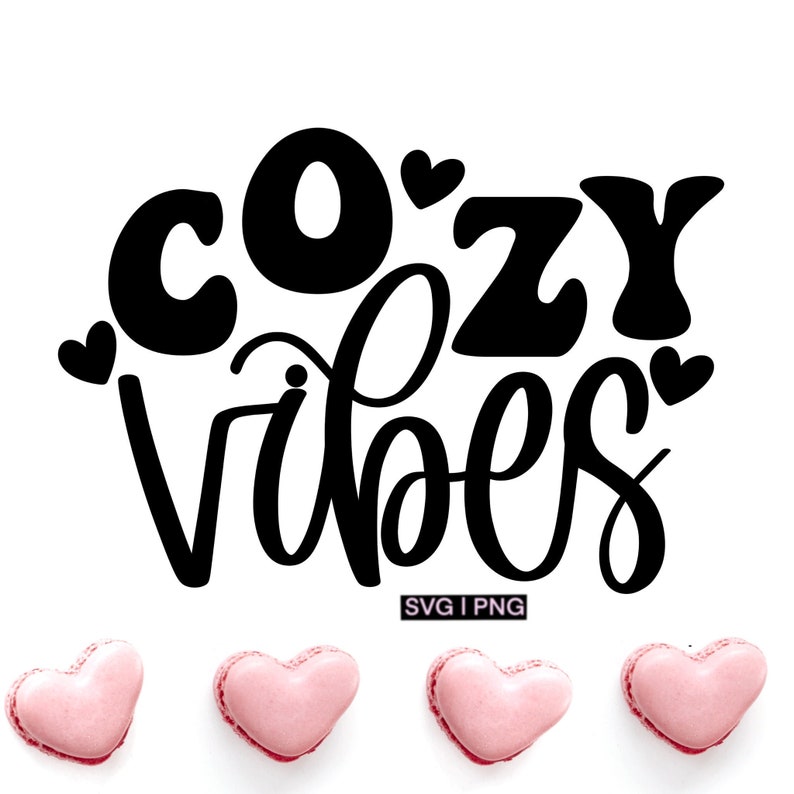 Puede incluir: Texto gr&aacute;fico en blanco y negro que dice "Cozy Vibes" con peque&ntilde;os corazones que rodean el texto. El texto est&aacute; escrito a mano. Hay tres macarons rosas en forma de coraz&oacute;n debajo del texto.