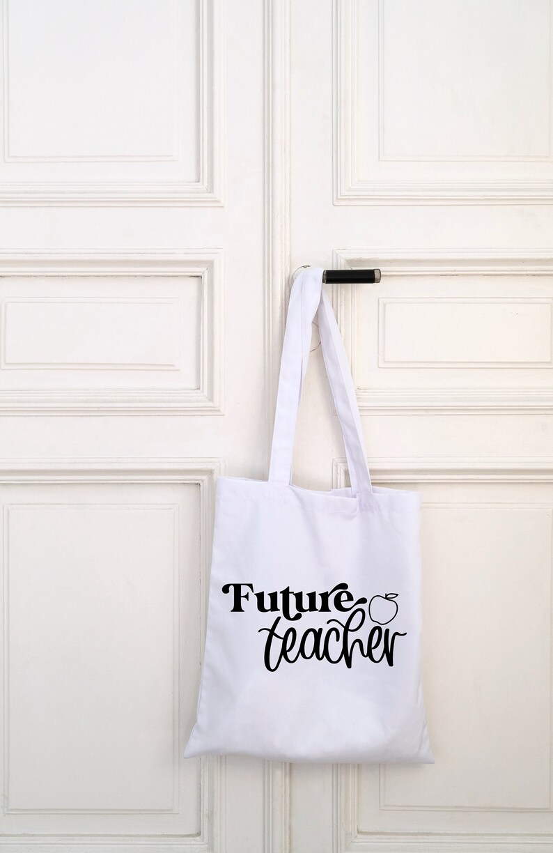 May include: White tote bag with black text that says "Future teacher" and a small apple graphic.