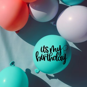 K&ouml;nnte beinhalten: Ein t&uuml;rkisfarbener Ballon mit dem Text "it's my birthday" in schwarzen Buchstaben, umgeben von rosa, wei&szlig;en und t&uuml;rkisfarbenen Ballons.