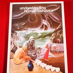 May include: A book cover with the title "understanding human behavior" and an illustrated cover featuring a sea monster, a woman in a red dress, a woman sitting on a beach, and a man with a beard. The cover also features a blue vase and a row of white teeth.