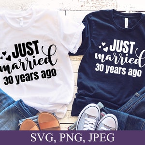 May include: Two white t-shirts with black text that reads "JUST married 30 years ago" and two small hearts. One t-shirt is white and the other is navy blue.