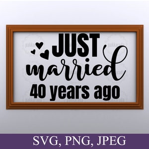 May include: A brown wooden frame with a white background and black text that reads "JUST married 40 years ago" with two hearts above the word "JUST".