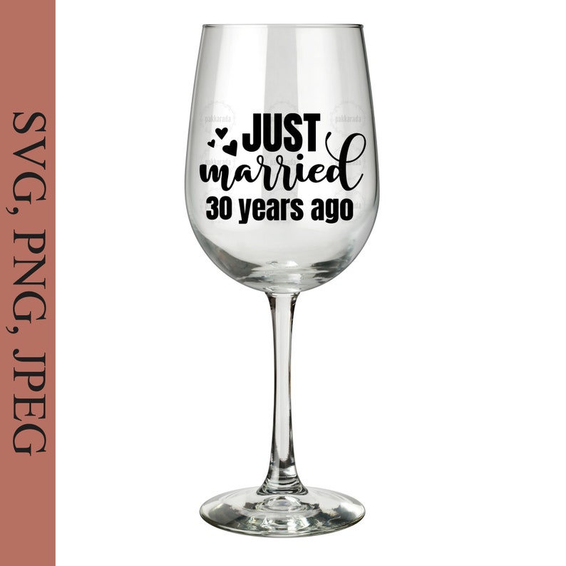 May include: A clear wine glass with a black design that says "JUST married 30 years ago" with two small hearts above the word "JUST".