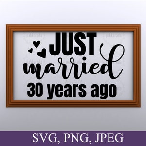 May include: A brown wooden frame with a white background and black text that reads "JUST married 30 years ago". There are three small hearts above the word "JUST".