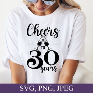 May include: White t-shirt with the text "Cheers to 30 years" in black script. The design includes two champagne glasses clinking together. The bottom of the image shows the text "SVG, PNG, JPEG" in white on a purple background.
