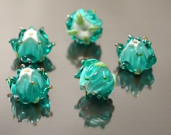 Handgefertigte Glasperlen in Blumenform, Schmuckherstellung, Glasblumen, florale Kunsthandwerksperlen, grüne, smaragdgrüne und weiße Glasperlen mit silbernen Punkten.