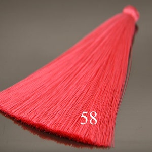 May include: A bright red tassel with a number 58 printed on it. The tassel is made of thin, silky threads and is approximately 10 inches long.