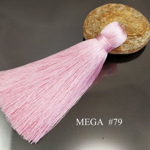 May include: A light pink tassel with a silver loop at the top. The tassel is about 6 inches long and is made of soft, silky threads. MEGA #79