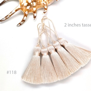 Puede incluir: Cinco borlas de color crema, cada una de 5 cm de largo. Las borlas están hechas de hilos suaves y sedosos y tienen un aspecto delicado y elegante. #118