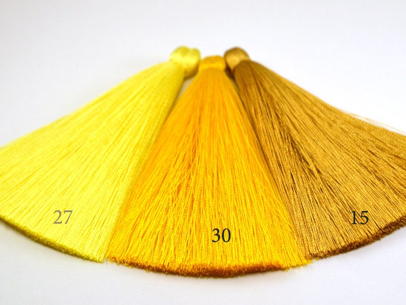 May include: Three yellow and gold silk tassels, with the numbers 27, 30, and 15 printed on them.