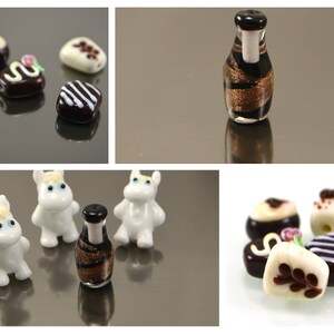 May include: Assortment of glass beads in various shapes and colors, including a bottle, a small animal, and a chocolate bar. The beads are made of glass and have a glossy finish.