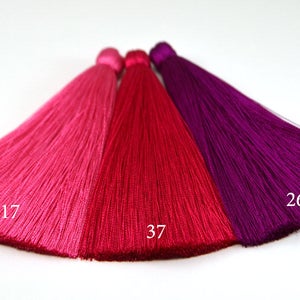 May include: Three silk tassels in shades of pink, red, and purple. The tassels are labeled with the numbers 17, 37, and 26.
