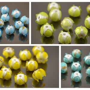 May include: Assortment of glass beads in various colors, including blue, green, yellow, and white. The beads have a flower-like design with five petals.