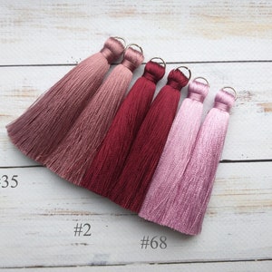 May include: Five silk tassels in shades of pink and burgundy. The tassels are labeled #35, #2, and #68.